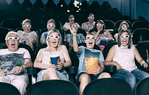 Menschen mit bunten Brillen in einem Kino.