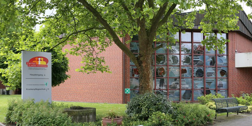 Außenansicht der Kirche im St. Vincenz-Altenzentrum, mit Wegweiser im Vordergrund.