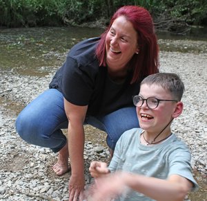 Junge Frau spielt mit Junge am Fluss
